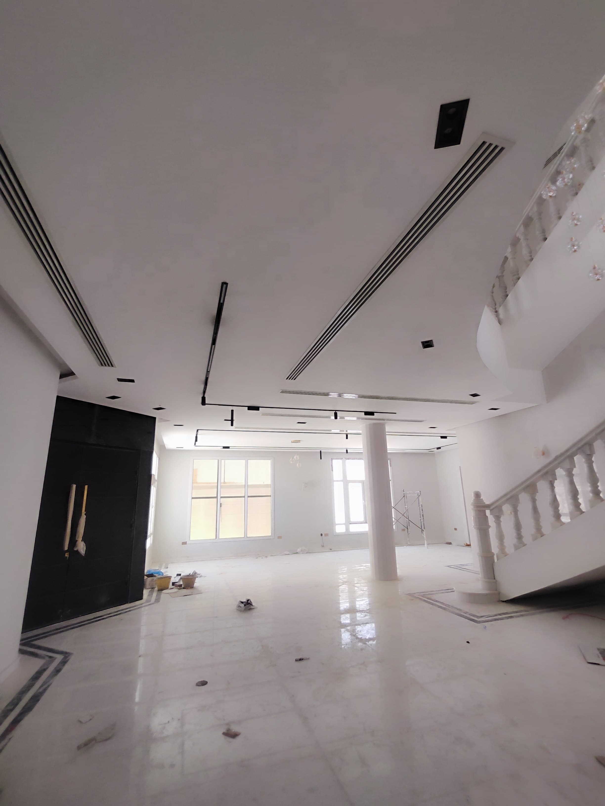 Gypsum false ceiling with coves, recessed track lighting and linear AC diffusers in a Qatar villa